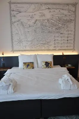 a bedroom with a bed with towels on it at Hotel Rauw aan de Kade in IJmuiden