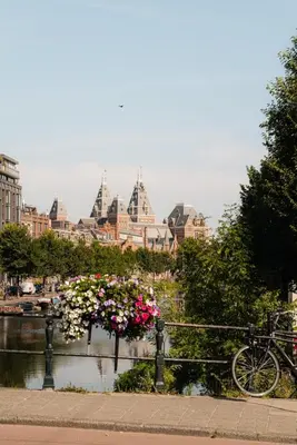a bike parked next to a river with buildings at Central Amsterdam Home Stay Near Museum Quarter & Vondelpark in Amsterdam