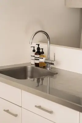 a kitchen sink with two bottles on it at Central Amsterdam Home Stay Near Museum Quarter & Vondelpark in Amsterdam