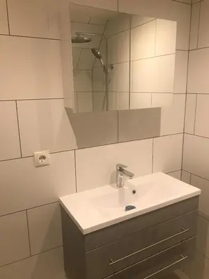 a white bathroom with a sink and a mirror at Penthouse Loft Central Harbour View, Free Parking in Ons Belang