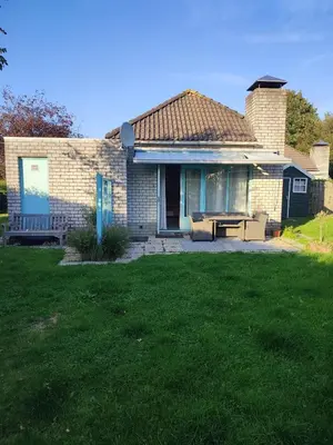a brick house with a bench in the yard at Gemütliches, komfortables Ferienhaus in Schoorl