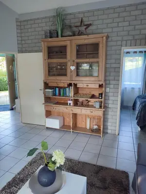 a living room with a wooden entertainment center at Gemütliches, komfortables Ferienhaus in Schoorl
