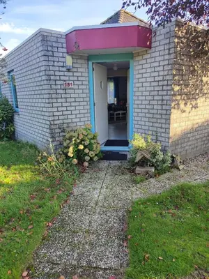 a small brick house with a blue door at Gemütliches, komfortables Ferienhaus in Schoorl