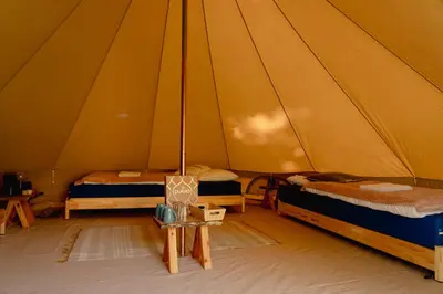 a room with two beds in a tent at Glamping belltent in het groen in Zeewolde