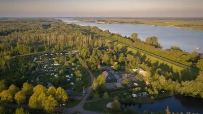 an aerial view of a park next to a river at Glamping belltent in het groen in Zeewolde