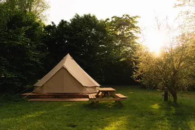 a tent with a picnic table in a field at Glamping belltent in het groen in Zeewolde