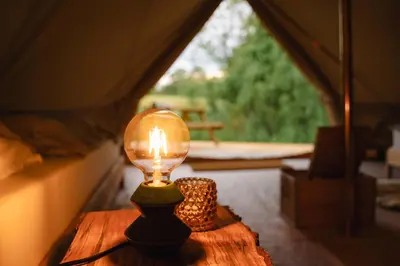 a light bulb sitting on a table in a tent at Glamping belltent in het groen in Zeewolde