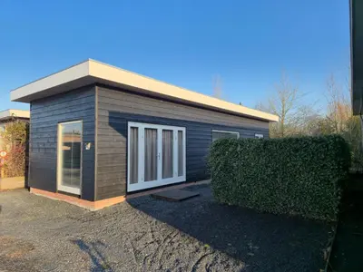 a small house with a hedge in front of it at Holiday home in the polder in Abcoude