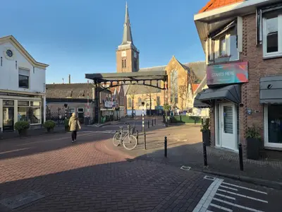 a woman walking down a street in a town at Holiday home in the polder in Abcoude