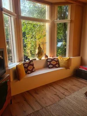 a window seat in a living room with pillows at Spacious Eclectic Home Near Sea & Amsterdam in IJmuiden