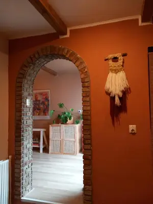 an archway in a room with an orange wall at Spacious Eclectic Home Near Sea & Amsterdam in IJmuiden