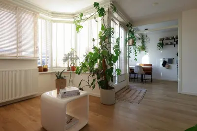 a living room with potted plants on the floor at East-Side Living in Amsterdam