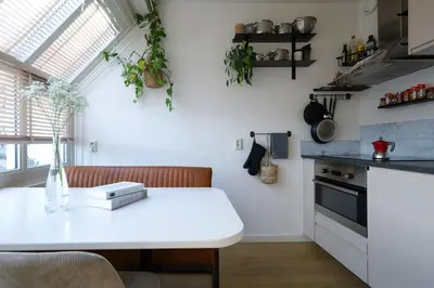 a kitchen with a white counter top and a table at East-Side Living in Amsterdam