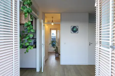 a hallway with a white door and a plant at East-Side Living in Amsterdam