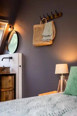 a bedroom with a bed and a mirror and a purse at Complete studio dichtbij Hoorn en Alkmaar in Zuidermeer
