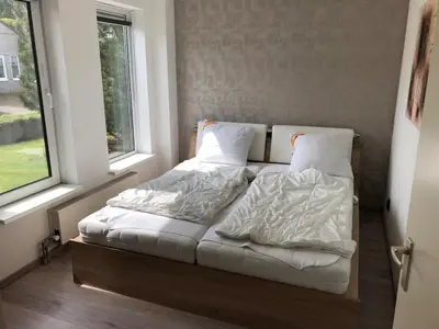 a bed sitting in a room next to a window at Ferienhaus Aan de Gracht - IJsselmeer in Wervershoof