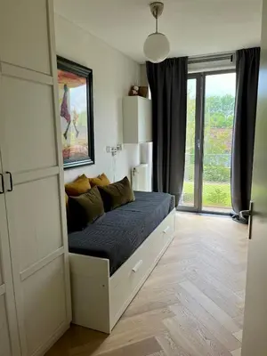 a bed in a room with a large window at Spacious and modern apartment in Amsterdam