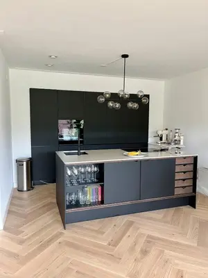 a kitchen with black cabinets and a counter top at Spacious and modern apartment in Amsterdam