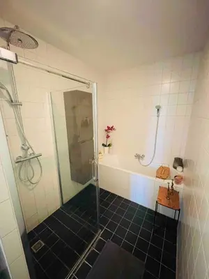 a bathroom with a shower and a tub and a sink at Spacious and modern apartment in Amsterdam