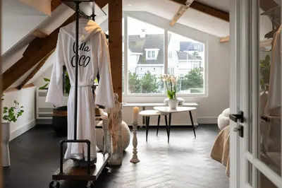 a room with a dress hanging in a room with a window at Villa COCO Aphrodite Apartment in Noordwijk