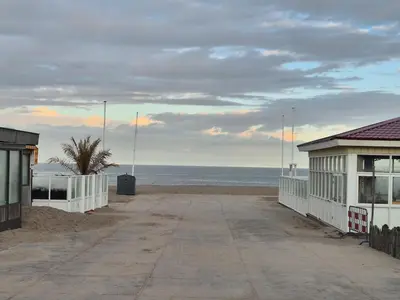 a beach with a building and the ocean at Ons Bijhuis in Wijk aan Zee
