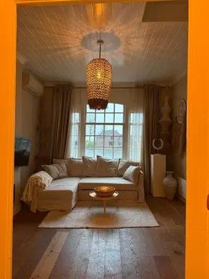 a living room with a couch and a table at White cottage on the Vecht! Beautiful surroundings in Nieuwersluis