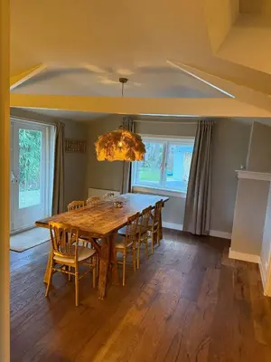 a dining room with a wooden table and chairs at White cottage on the Vecht! Beautiful surroundings in Nieuwersluis