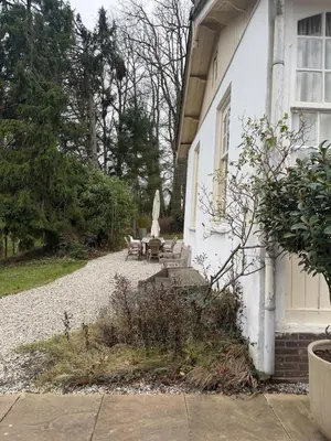 a white house with a bench and a table at White cottage on the Vecht! Beautiful surroundings in Nieuwersluis