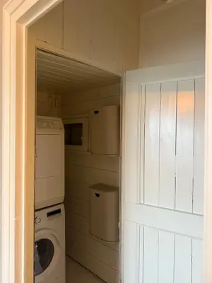 a small laundry room with a washer and dryer at White cottage on the Vecht! Beautiful surroundings in Nieuwersluis