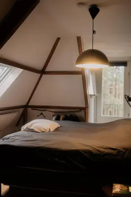 a bedroom with a large bed with a large window at Klein Nieuwe Wegen in Ons Belang