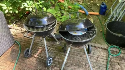 two bbqurgers are sitting on the ground at Klein Nieuwe Wegen in Ons Belang