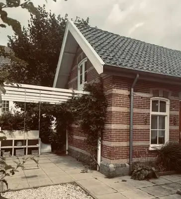 a red brick house with a white roof at Maison 1882 in Hauwert
