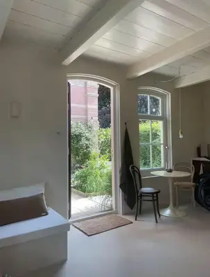 a living room with a table and a window at Maison 1882 in Hauwert