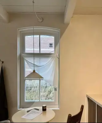 a window in a room with a table and a lamp at Maison 1882 in Hauwert