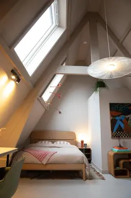 a bedroom with a bed and a large window at The Painters Loft sleeping among the art in Haarlem