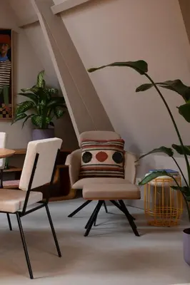 a living room with two chairs and a plant at The Painters Loft sleeping among the art in Haarlem
