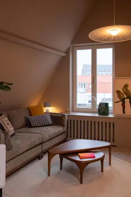 a living room with a couch and a coffee table at The Painters Loft sleeping among the art in Haarlem