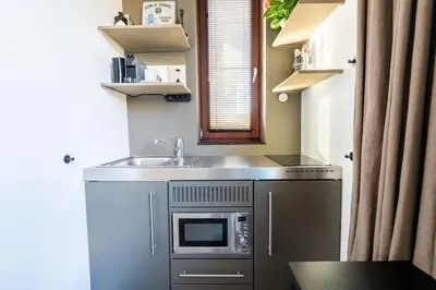 a small kitchen with a sink and a microwave at NEW! Cozy Studio 54 in Amsterdam
