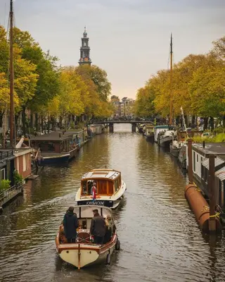 two boats in a canal with people on them at NEW! Cozy Studio 54 in Amsterdam