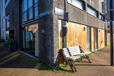 a wooden bench sitting outside of a brick building at NEW! Cozy Studio 54 in Amsterdam
