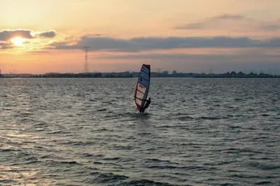 a person windsurfing on the water at sunset at NEW! Cozy Studio 54 in Amsterdam