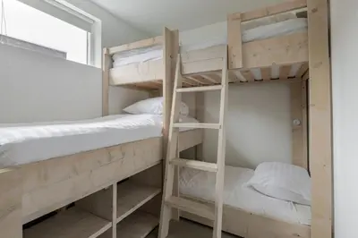 a bunk bed room with two bunk beds and a window at Rekerlanden 58 - De Boet in Warmenhuizen