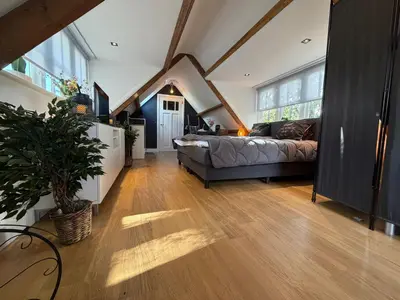 a large living room with a bed and a couch at Fuchsiahoeve in Blaricum