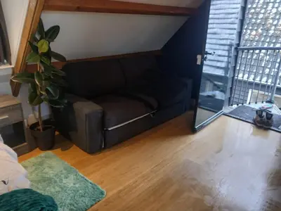 a living room with a couch and a window at Fuchsiahoeve in Blaricum