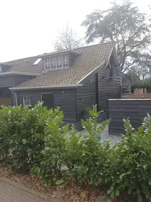 a house with a roof and some bushes at Fuchsiahoeve in Blaricum