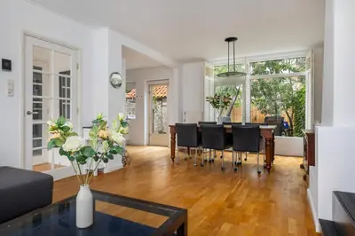 a dining room and living room with a table and chairs at Lovely House in Zeist