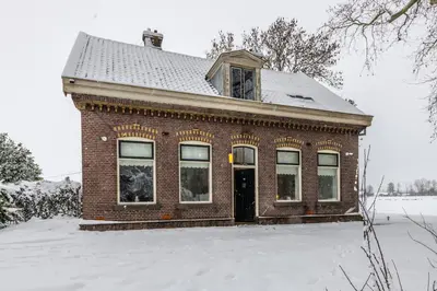 a red brick house in the snow with snow at Private Estate Villa near Amsterdam with Hottub 12p in Abcoude