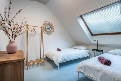 a attic bedroom with two beds and a vase with flowers at Private Estate Villa near Amsterdam with Hottub 12p in Abcoude