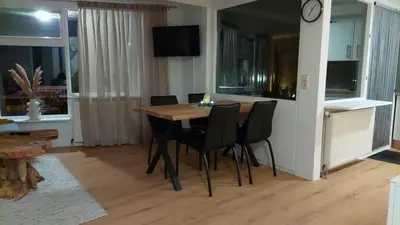 a dining room with a table and black chairs at Ferienwohnung Nordholland in Nieuwe-Niedorp
