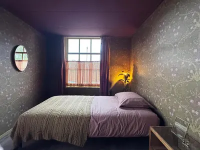 a bedroom with a bed and a window at De Noorderzon in Benningbroek